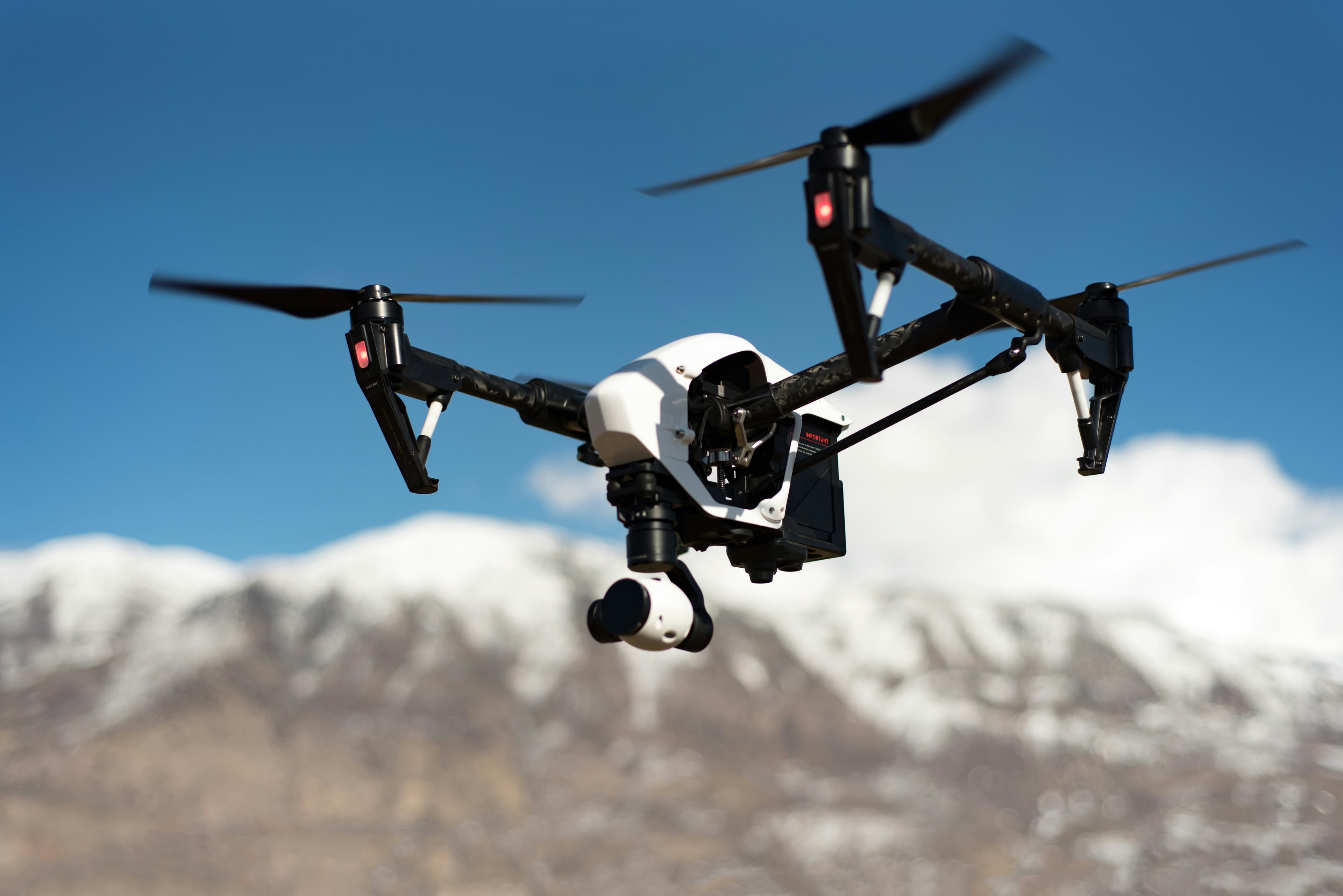Stealthy military drone in flight over mountains.